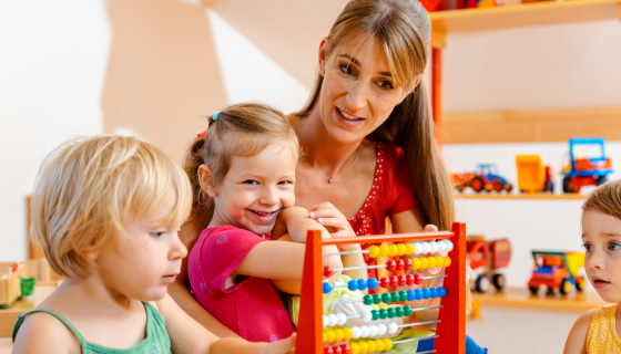 Childcare educator playing with two children 