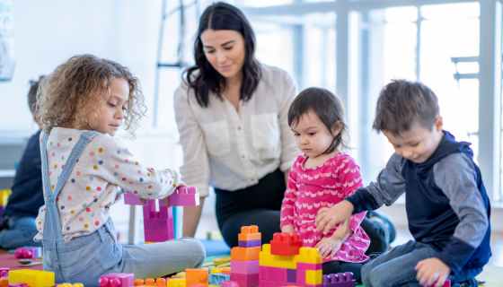 Children playing blocks with an educator 