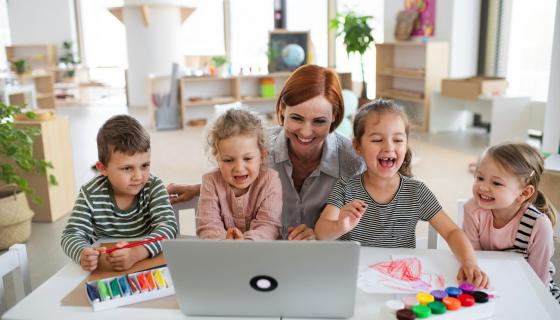 Childhood educator in front of a computer with children