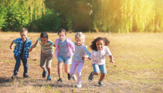 5 children run toward the camera in a sunny dry field