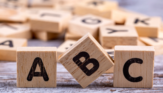 wooden Scrabble tiles lined up to spell ABC