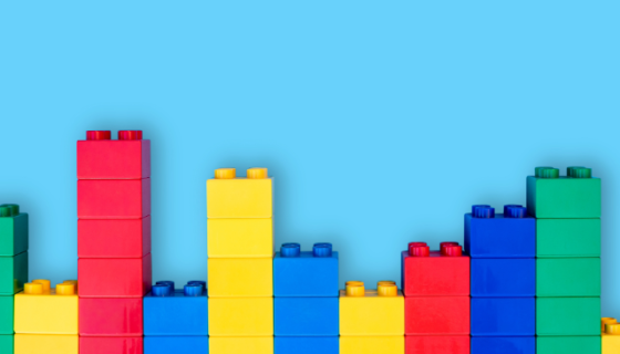 Multicoloured duplo blocks stacked in columns against a blue background