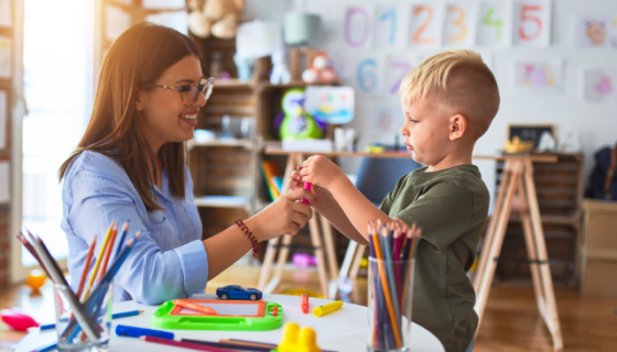 An educator passing a toy to a child