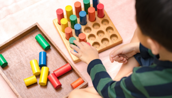 An image showing a birds eye view of a child playing with colourful blocks