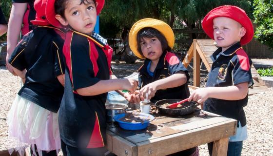 Children playing at a mud kitchen outdoors